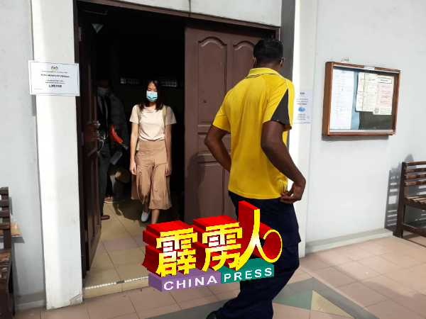 身穿黄衣的被告苏古，离开法庭见到媒体时别过脸躲避镜头。