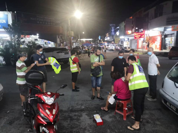 妇女遭掠夺匪强扯包包后不慎跌倒，肩膀及手肘受伤，治安巡逻队员协助其包扎伤口。