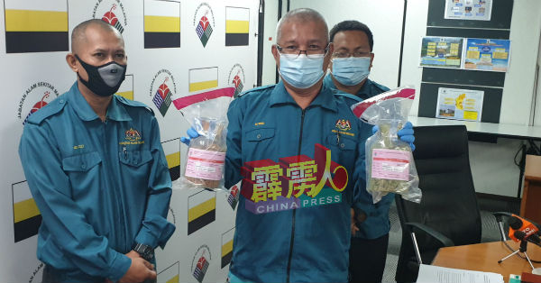 罗斯里(中)展示采集的绿色泥土样本。