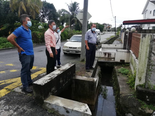 青屋区拿坡路的民宅前排水沟,排水功能欠佳引起关注,左2为廖泰义。
