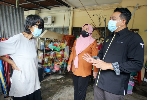 阿末赛迪(右起)及旺诺拉斯京再三劝解曾女士,勿再继续囤积垃圾。