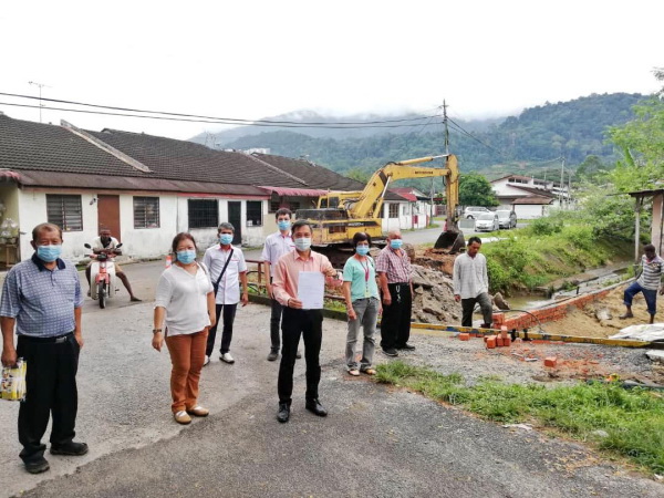 廖泰义(中)展示早前向太平市议会申请工程的批准信函,左2为廖皎韵。