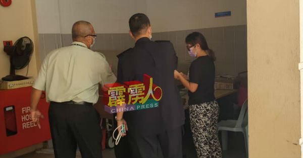 男死者黄志伟妻子，从后门进入太平间办理丈夫遗体认领手续。