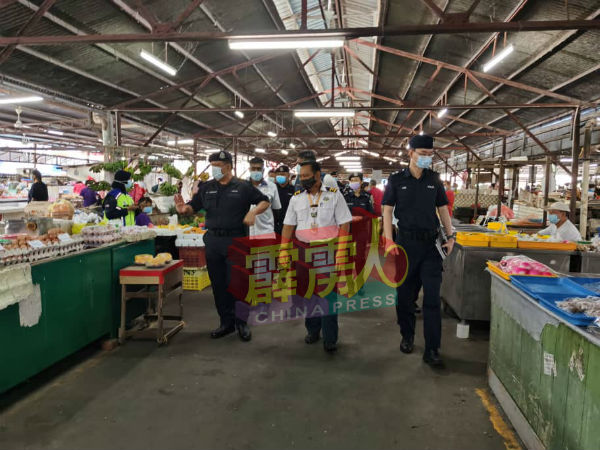 怡保警方于周二（3日）拉大队巡视崑喇叭巴剎小贩及市民是否有遵守标準作业程序。