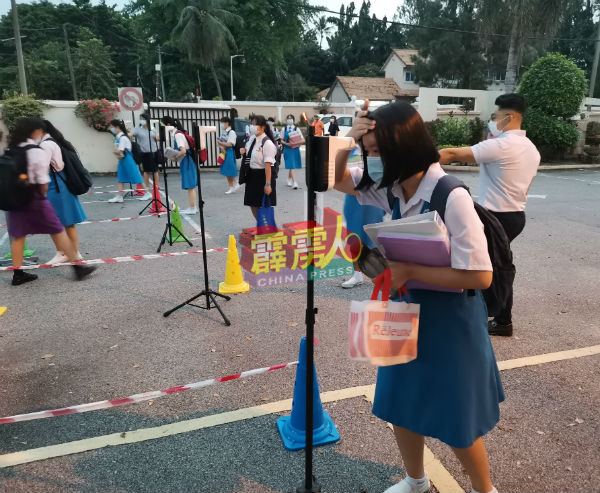 学校在7月復课时，在校门口设立站立式体温测量仪器，让学生快速测量体温，随后才进入课室上课。（档案照）