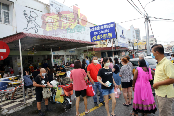 跨州解禁后，琼南茶餐室虽重现人潮，但业者及食客都严守标准作业程序。
