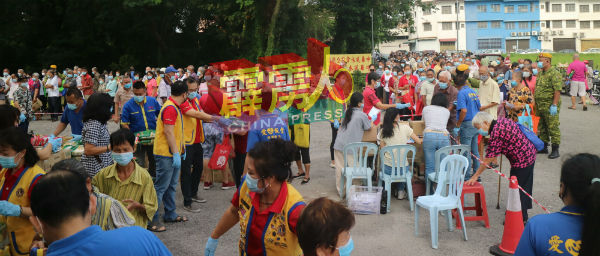 警卫局成员协助维持秩序，义工则为受惠者测量体温丶洗手及派口罩。