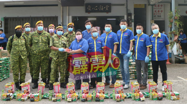 黄美圆（右7起）移交援助品给警卫局成员，并由陈汉强代表接领；右起为徐铭健丶李荣强丶何盛隆丶易俊宏丶黄烈及莫少荣。