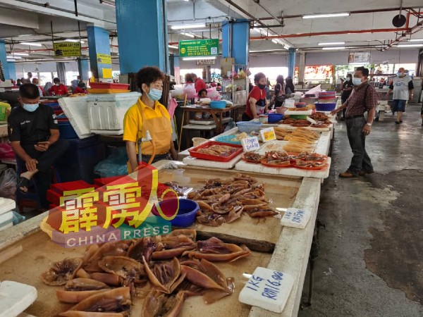 鱿鱼生意冷清，一大早开市，仅有少数顾客光顾。