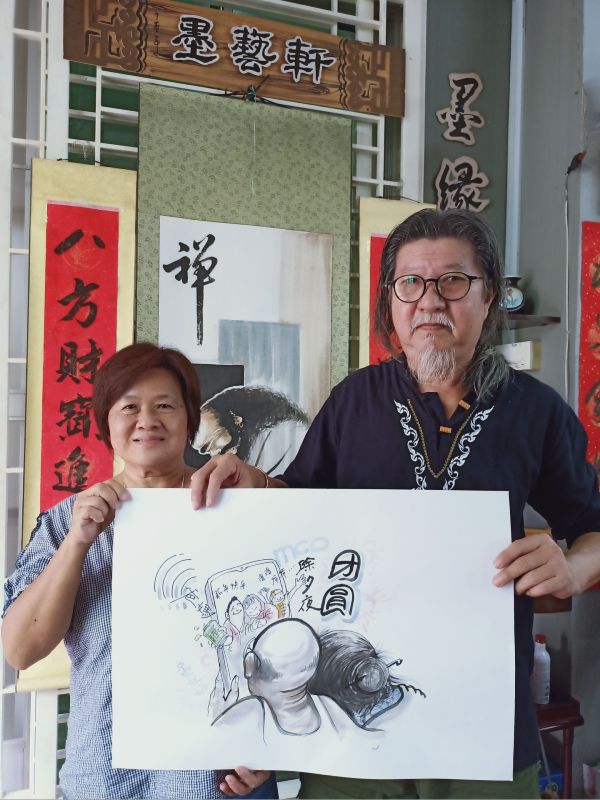 李朝俊与黄月明，展示“团圆”画作，藉此以画寄情。