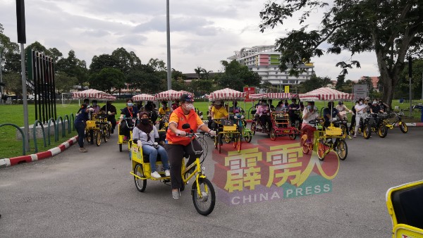 20馀名视障人士在导游及义工陪同下，骑着脚车游DR公园。