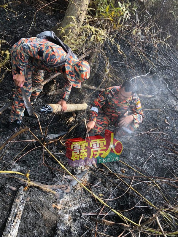 消拯员检查火苗是否已完全熄灭。