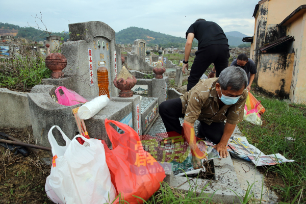 民众在祭祖前清理一下墓地杂草，才准备香案。
