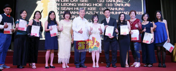 廖瑞芳（左5起）陪同刘殷铨及陈帼英，颁赠服务奖给中学老师。