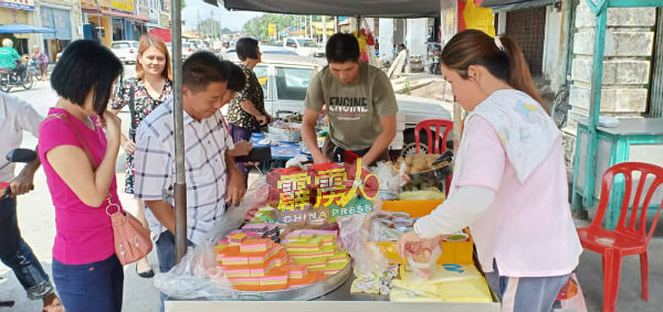 布先大街的茶果摊位售卖的糕点吸引村民及外地食客购买。