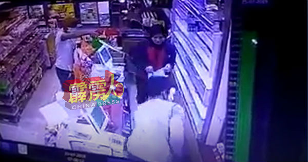 劫匪以巴冷刀指向女店员，勒令她将香烟放入袋子内。