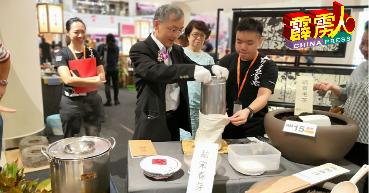 许崇信（前排左）在场体验如何制压普洱茶饼的工艺技术。