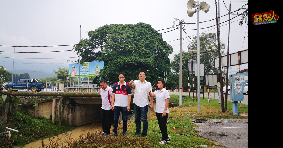 徐保萍（右起）、罗思义、吴鍚华及刘宝健，在和丰市区（消拯局对面）竹芭河岸探讨竹芭河的情况。他们身后就是水灾预警系统。