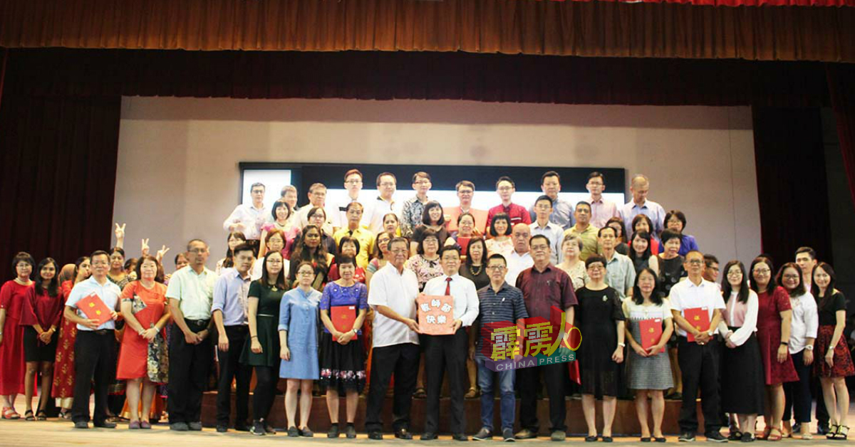 全体教职员获得育才独中董事部派发的红包，由吴国芳（前排左8）代表移交给苏民胜（前排左9）。
