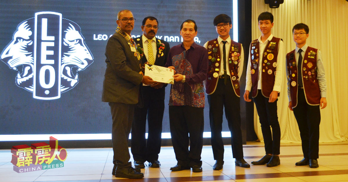 实兆远狮子会前主席孙得拉山（左）颁赠表扬状，予实兆远南华华中校长曾义芳及该校幼狮会代表。