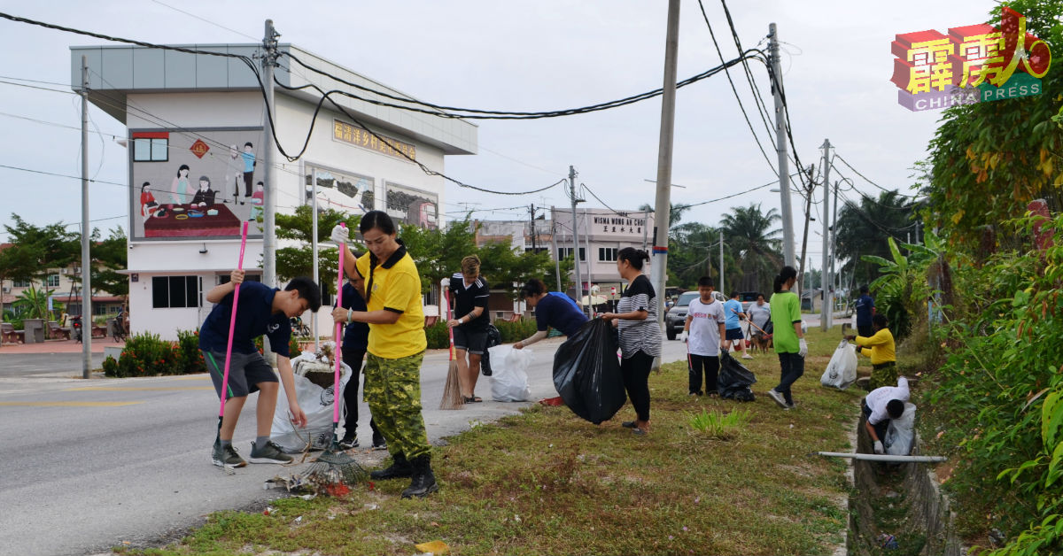 大人小孩响应福清洋新村的清洁运动，沿着当地主要道路清理垃圾。