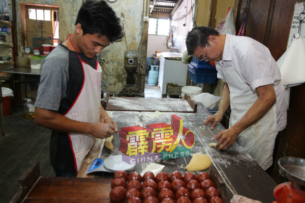 罗振盛（右）与员工忙于制造传统月饼。