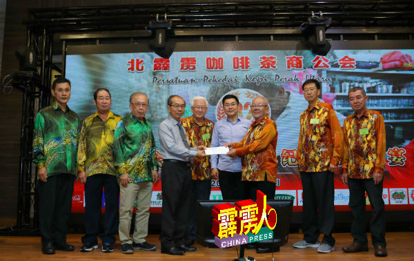何子孟（左4）代表总会移交捐款支票给财政吴天顺，张国梁（左5起）与郑国霖等嘉宾见证。