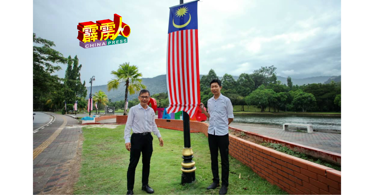廖泰义（左）与卢德渊巡视太平湖“I LOVE TAIPING”牌景点的国旗悬挂情况，感到满意。