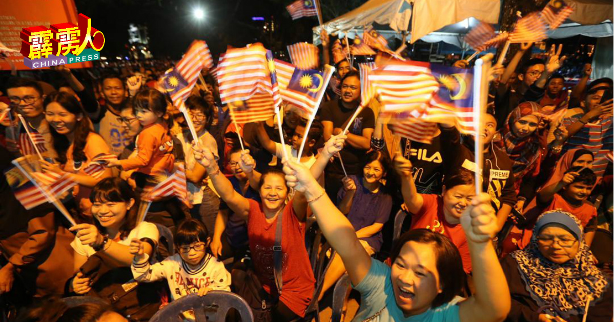 民众配合爱国歌及表演，纷纷摇动手中的小国旗，现场顿时一片旗海。