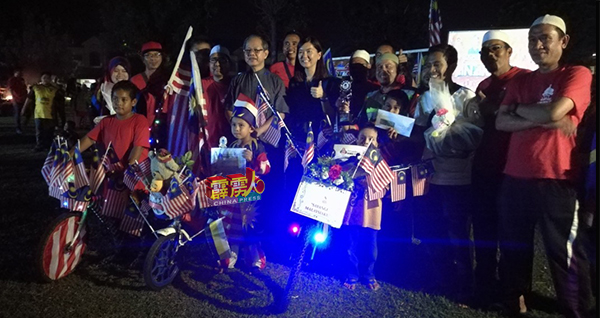 李文材（左4起）与黄诗情为大会颁发奖品予马来西亚日国旗脚车装饰比赛的优胜者后，分享喜悦。