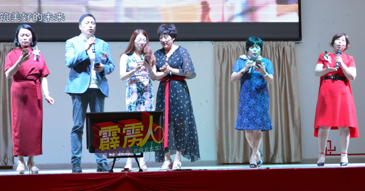 何良金（左2）、黄秀华（右）和中国数家企业代表，为活动献唱。