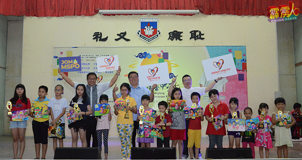 李政耀（后左起）、苏建祥、吴乃鸿高举“爱我油棕”纸牌，与填色比赛得奖者分享喜悦。