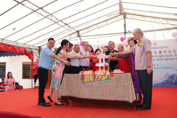 李文材（右5）与一众理事，为怡保幸福村老人院的老人庆祝生日。