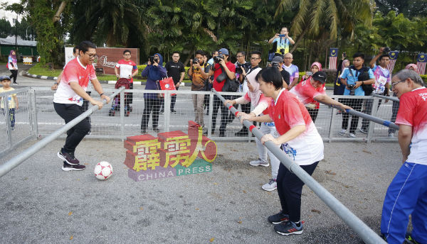 阿末法依扎（左）参与怡保市甚是少见的人化桌面足球运动，过程相当紧张及有趣，逗乐在场者。