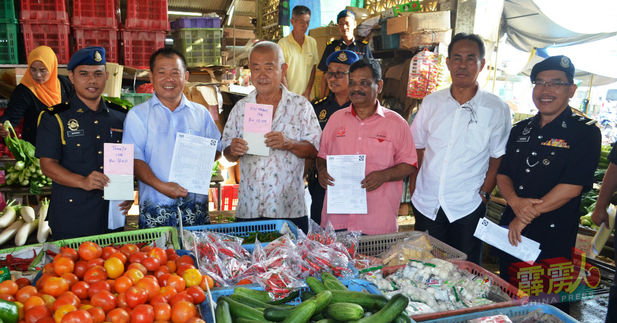 巴鲁（左起）和彭宏钟赞扬爱大华小贩在所成列的统制品展示粉红标籤，让消费者一目瞭然。