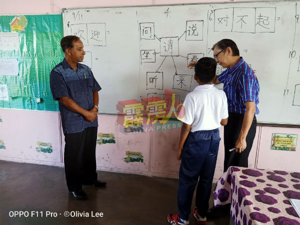 学生（右起）在执教老师吴国民牵引下，说出相当流畅的中文给古拉听听。