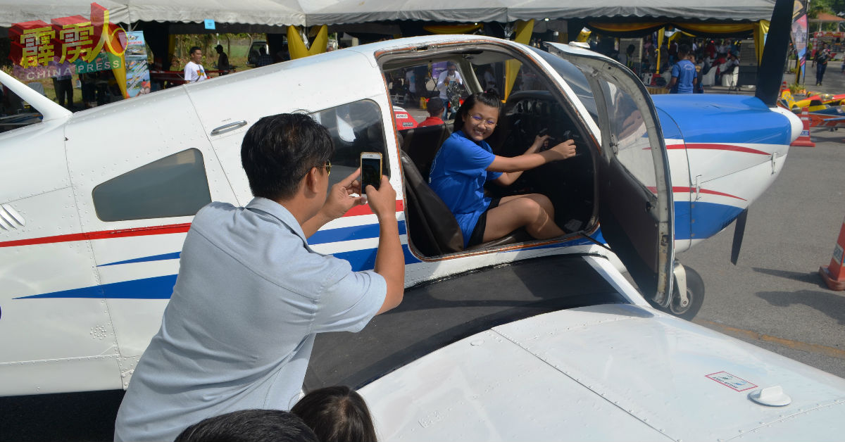 民众在小型飞机内拍照纪念。
