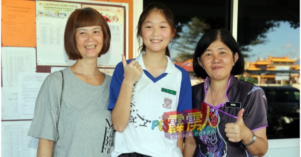 林丽心（中）凭着对排球有着坚韧的毅力及努力，获得武吉加里尔体育学校录取入读，左起母亲廖玉霞及校长黄丽娟。