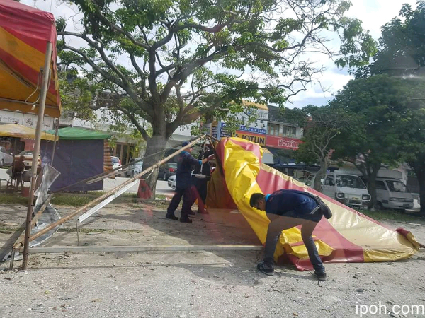 根据网站流传的照片显示，怡保市政厅执法人员拆除年货贩商布棚。（图取自ipoh.com）。