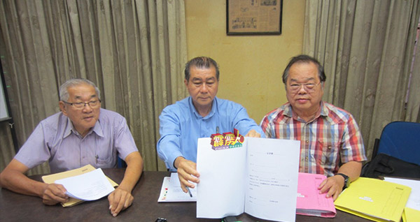 李官仁（中）、温立达（左起）及郑东旺展示供华小签署反对爪夷文列华小国语课本单元表格。