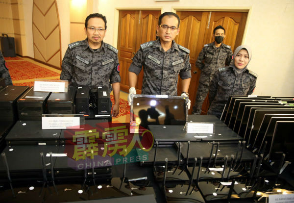 卡马鲁丁（左起）及英德拉凯鲁展示当局起获的各种电脑器材。