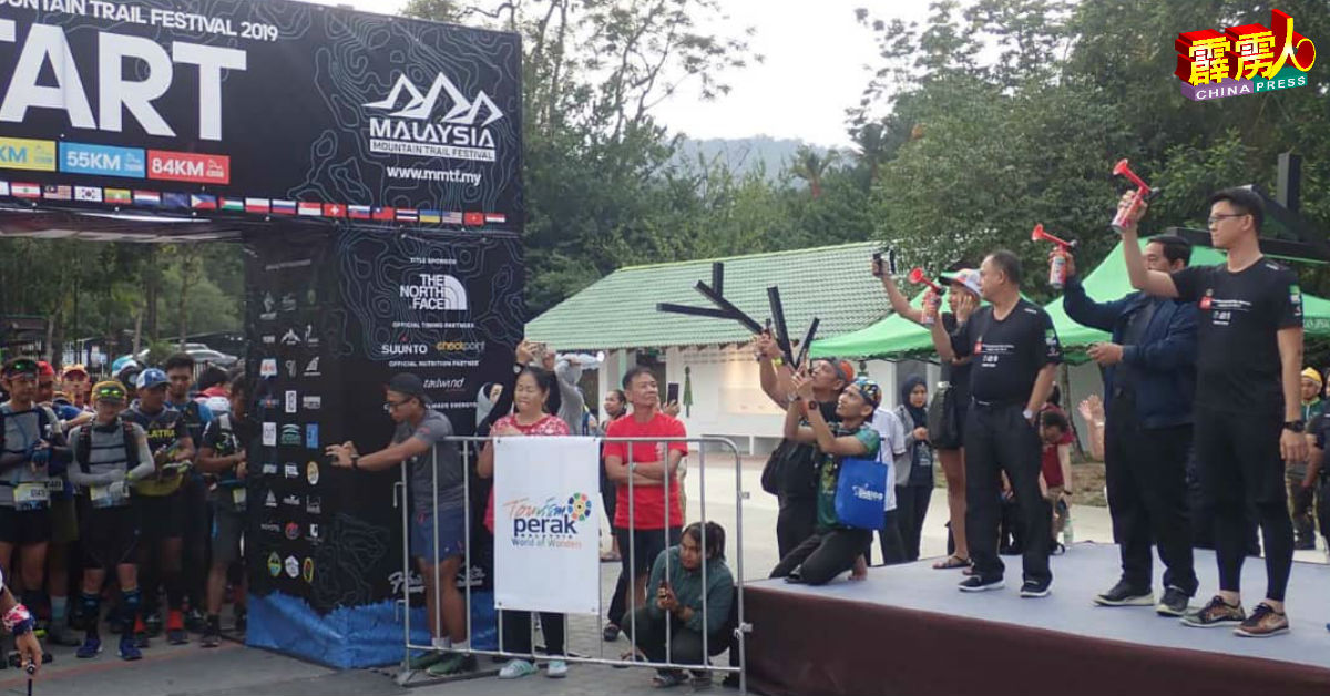 陈家兴（右）为马来西亚登山节的55公里赛事主持鸣笛开跑仪式。