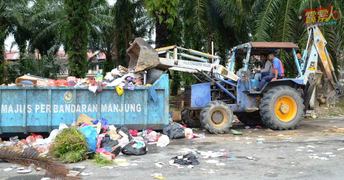 曼绒市议会员工在清理班台卫星园垃圾槽。
