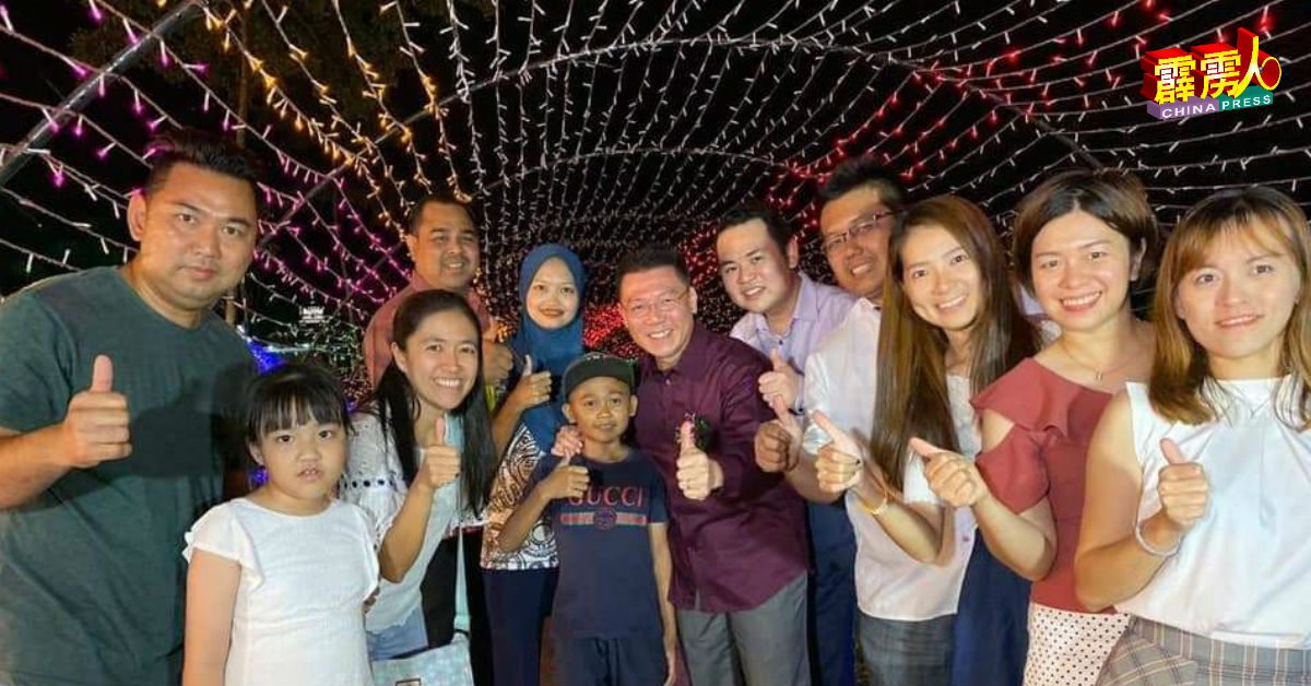 倪可敏（左7起）、张哲敏与祝英杰，与友族同胞及《爱.心》团队成员，一起在星光隧道前合照。
