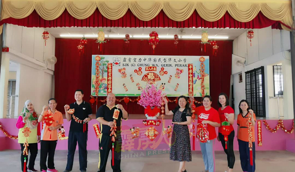 宜力中华华小校长何骏华（左4）丶家协主席罗健萍（右3） ■与其他家长和老师，把礼堂的伸展台布置的美轮美奂。