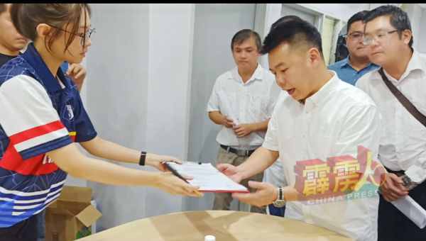 刘国南（右2起）在张哲敏服务中心，移交要求对方一起报警和举报的邀请函，由行动党金宝县议员郑歆妤接领。