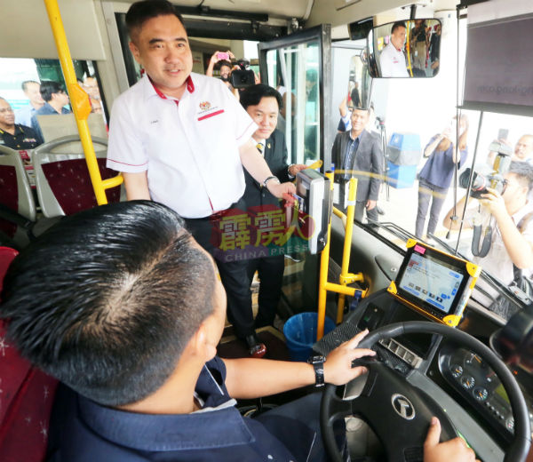 陆兆福使用一触即通卡，乘搭“怡保我的巴士”。