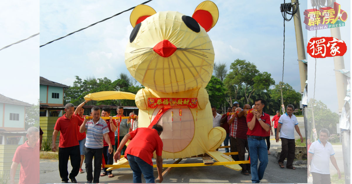 爱大华拉惹依淡新村村民扛13尺高“金鼠”游村迎新年。