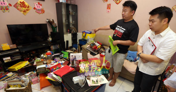 饶尚才（左）向刘国南展示住家客厅被翻箱倒箧。
