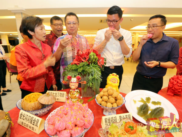 郑立慷（右起）、陈家兴、罗智柔品嚐由马来西亚华人妇女协会准备的莲花盛开、百事亨通（莲花酥），并由关洺洙（左）在旁讲解。